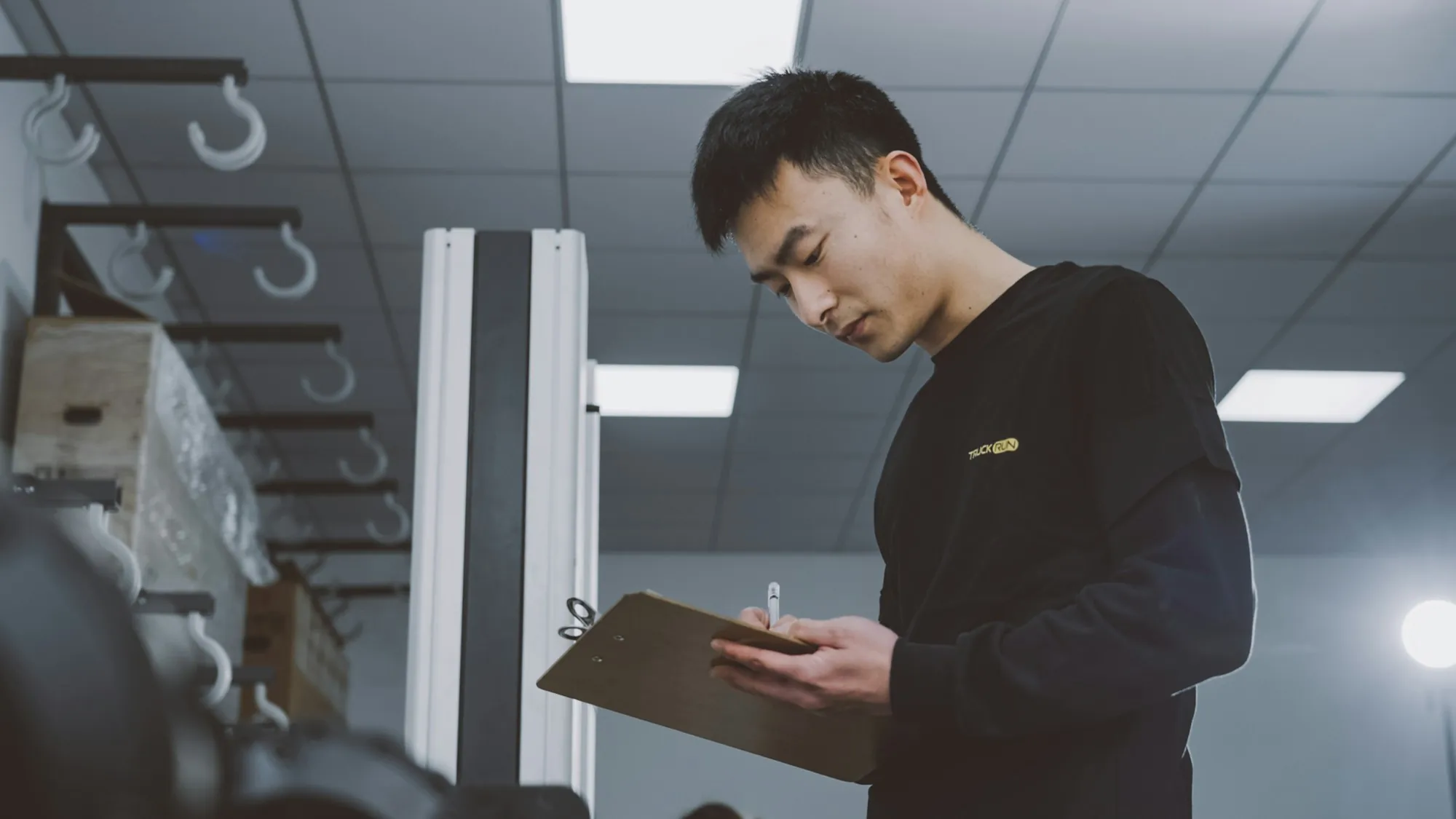 Electrician checking notes on a clipboard during a site visit