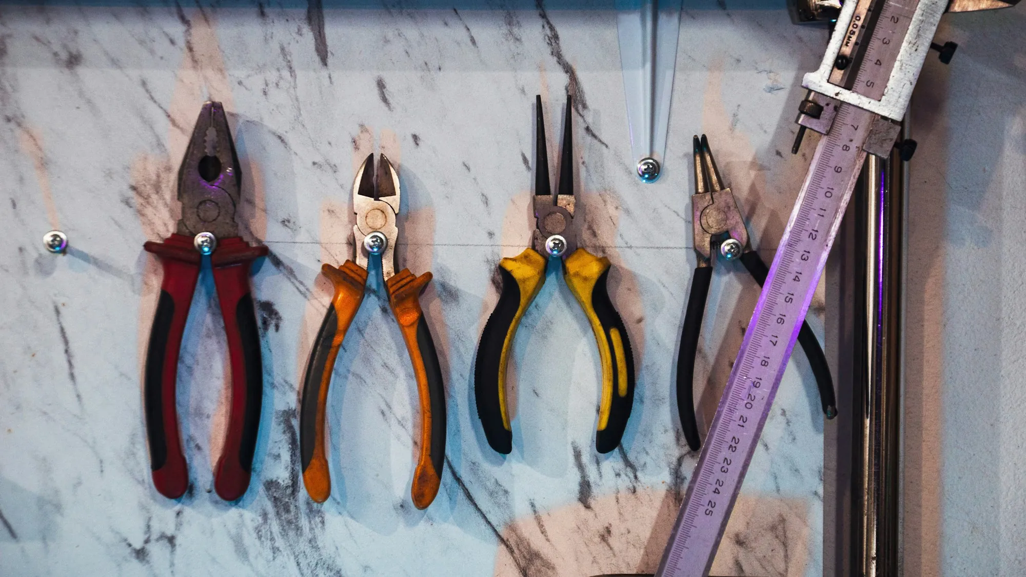 Electrician pliers and wire cutters hanging on a workshop wall