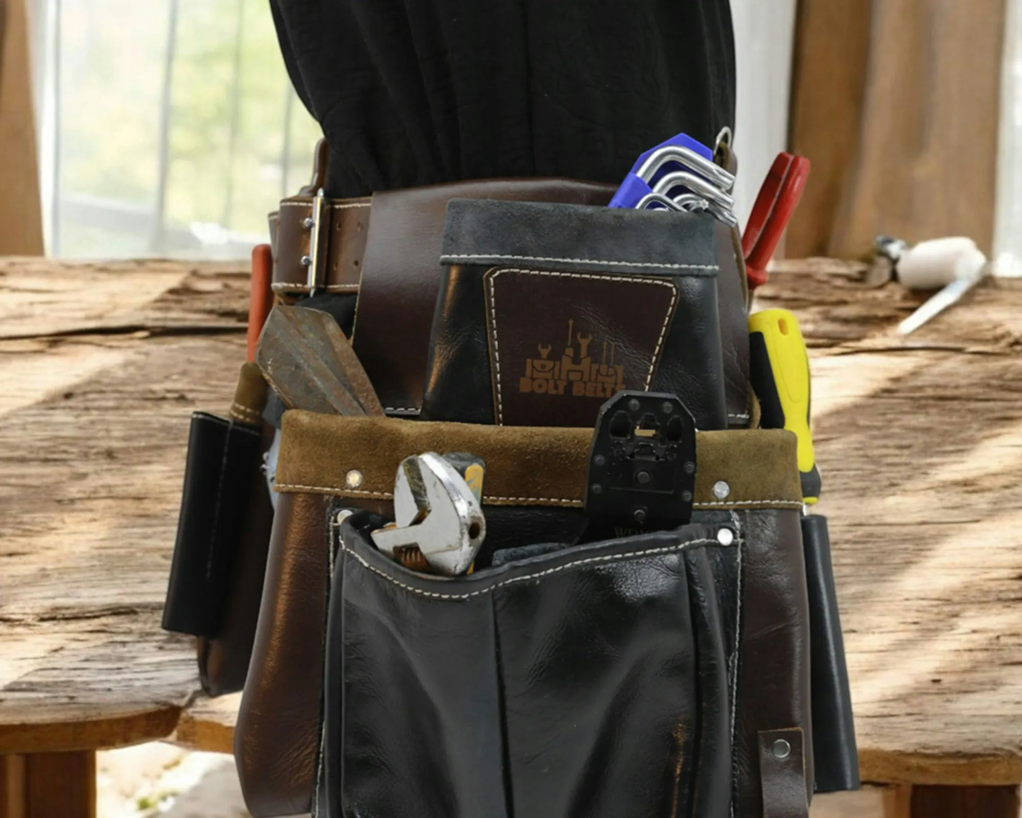 Electrician tool belt with pliers and screwdrivers on a workbench
